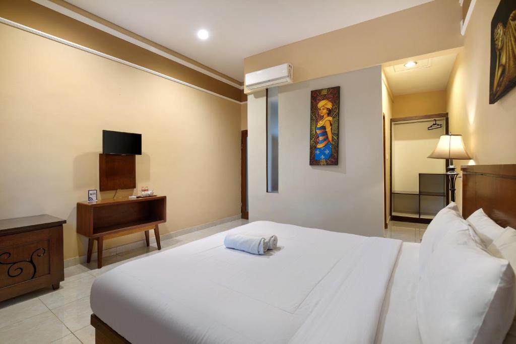 Una cama o camas en una habitación de Mahe Garden Inn and Villas by Kamara