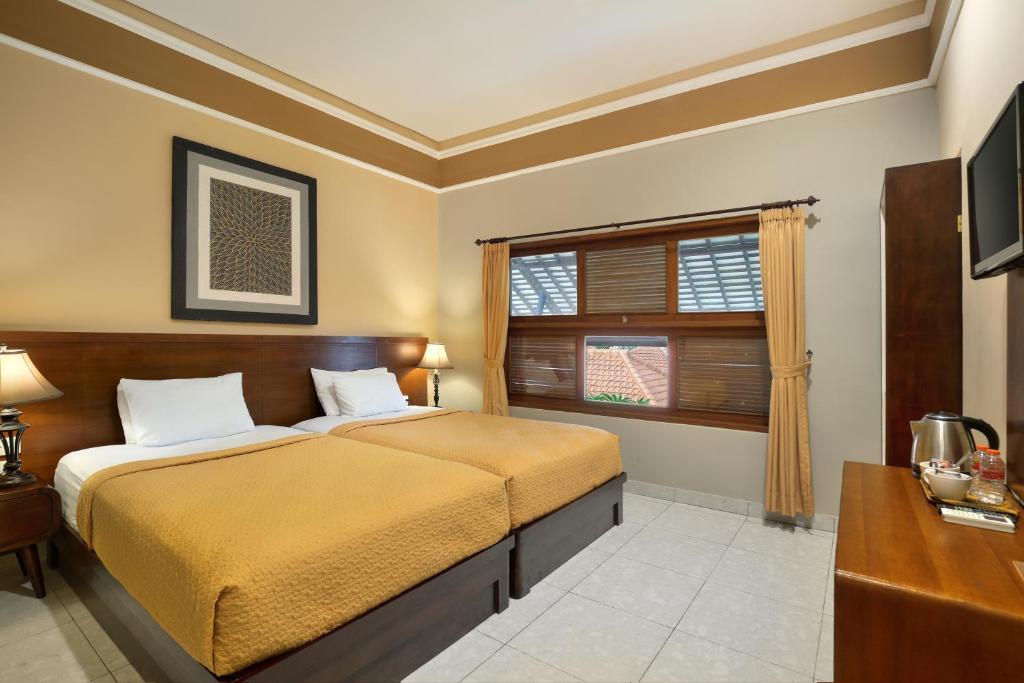 Una cama o camas en una habitación de Mahe Garden Inn and Villas by Kamara