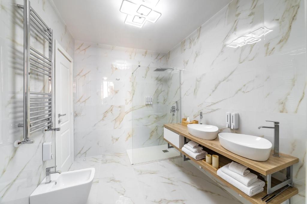 a white bathroom with two sinks and a shower at iRoome in Rome