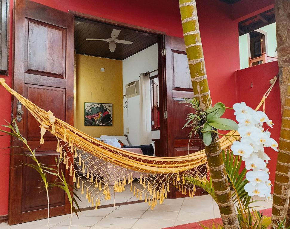 a hammock in a room with a palm tree at Pousada Lira Praieira Paraty in Paraty