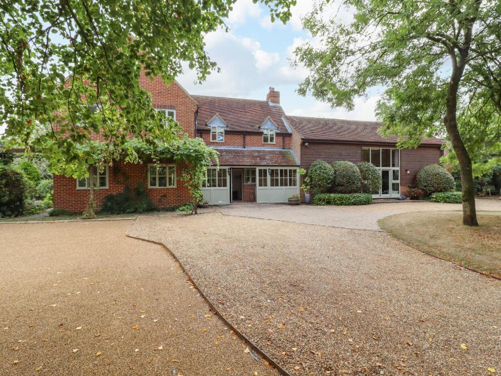 a brick house with a driveway in front of it at Yew Tree Farm in Aylesbury