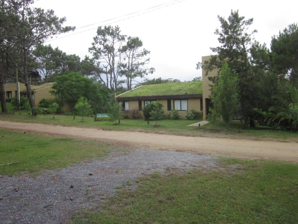 una casa con techo verde en un camino de tierra en Miraverde, en Piriápolis