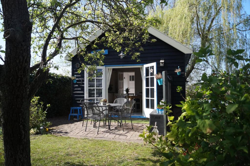 una pequeña casa azul con mesa y sillas en Hortensia Eiland, en Zegveld