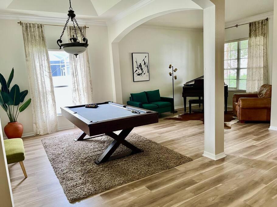 a living room with a pool table and a piano at Sandy Oasis 5 bedroom with Pool Sarasota Bradenton in Bradenton