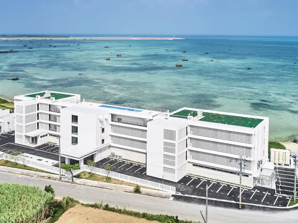 an aerial view of a white building next to the ocean at Watermark Hotel Okinawa Miyakojima in Miyako Island