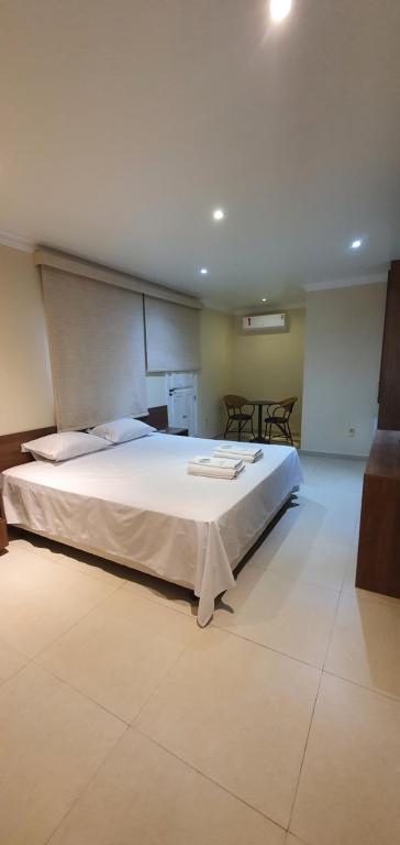 ein Schlafzimmer mit einem großen weißen Bett in einem Zimmer in der Unterkunft Pousada Dom Quixote in São João da Barra