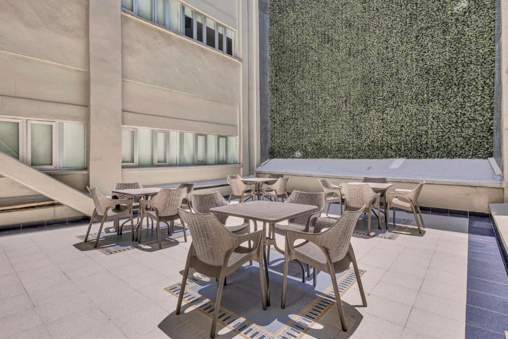 a patio with tables and chairs in a building at One Ciudad de Mexico Alameda in Mexico City