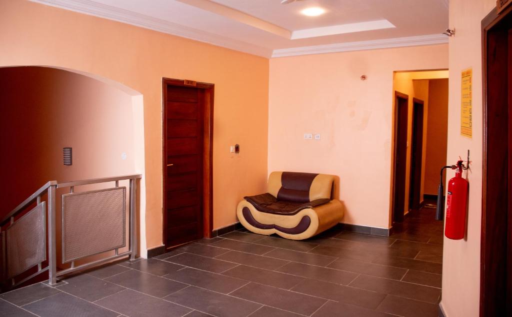 una habitación con una silla en el medio de un pasillo en El-King Home Lodge, en Afwerasi