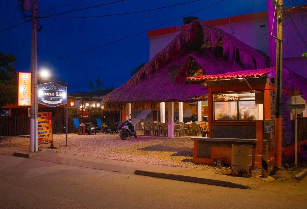 a restaurant with a purple roof at night at Mama Lira in Coveñas