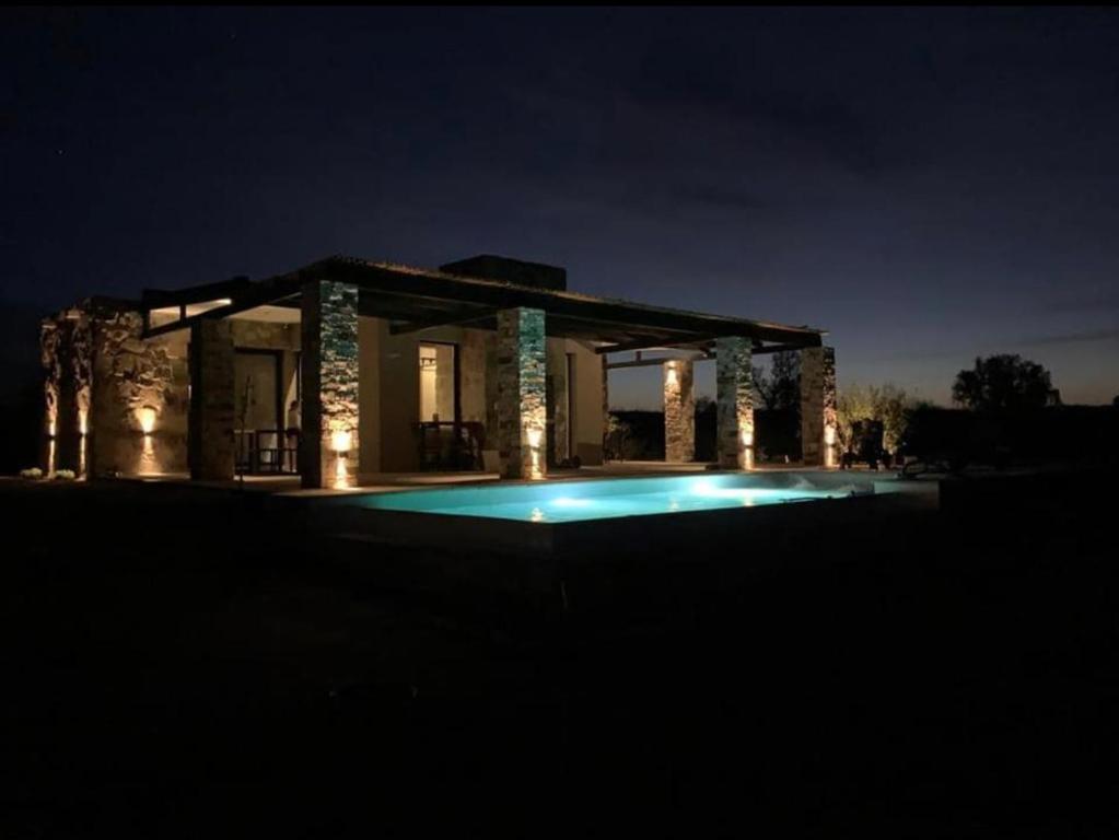 a house with a swimming pool at night at Casa Pueblo Benegas in San Rafael