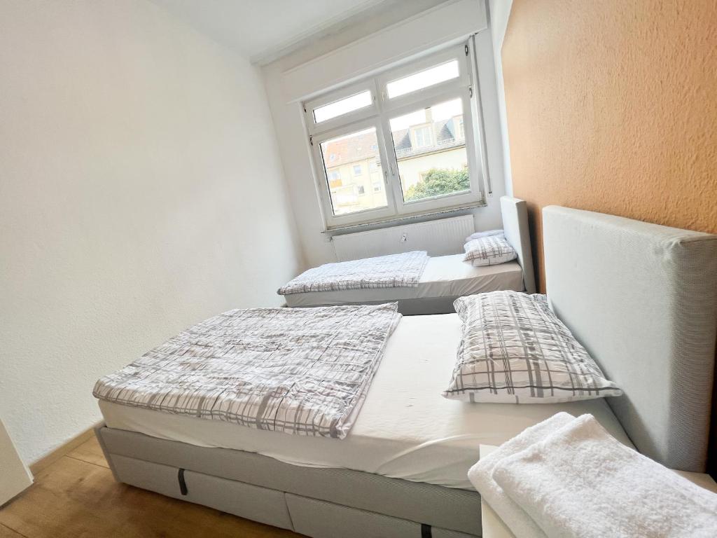 Duas camas num quarto com uma janela em Bezaubernde Wohnung in zentraler Lage em Karlsruhe