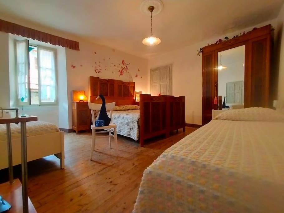 a bedroom with two beds and a chair in it at Il gioco dell'oca in Ponna Superiore