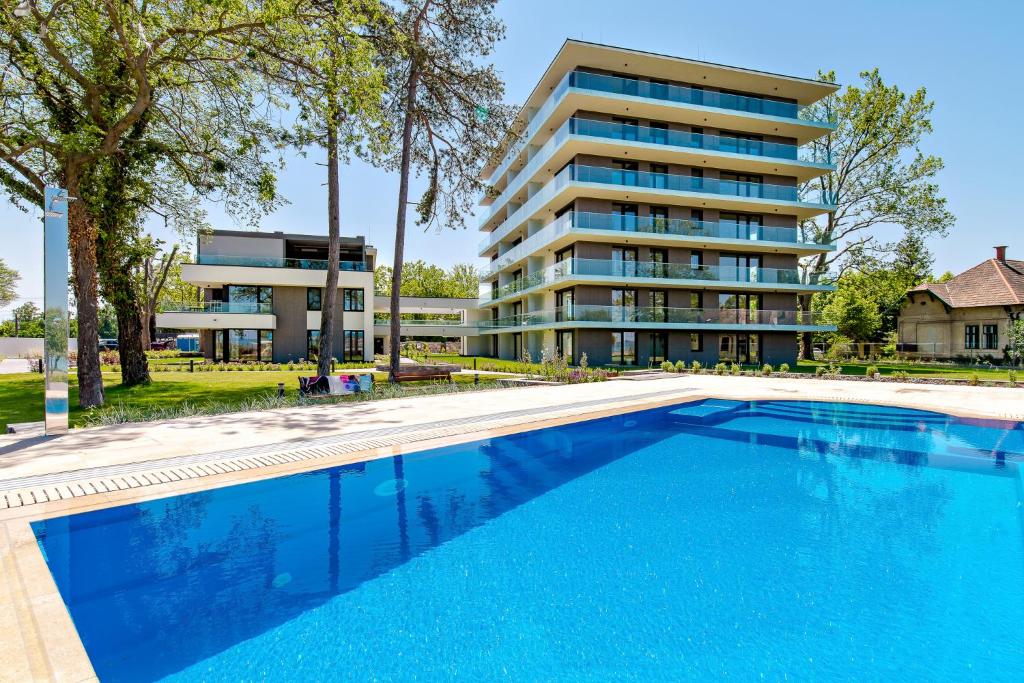 an empty swimming pool in front of a building at Premium Lelle Waterfront Resort Clyde in Balatonlelle