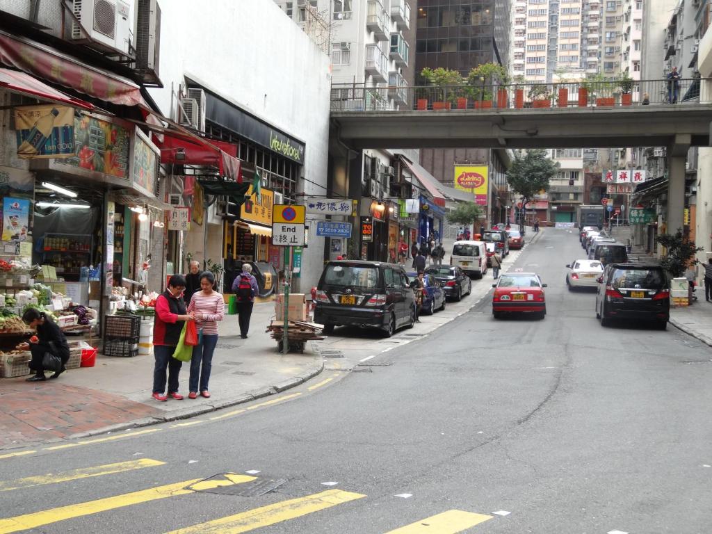 a group of people standing on a city street at Ibis Hong Kong Central & Sheung Wan in Hong Kong