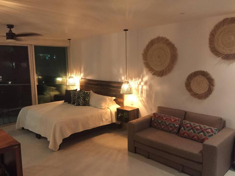 a bedroom with a bed and a couch at Estudio acogedor con vista al mar in Nuevo Vallarta