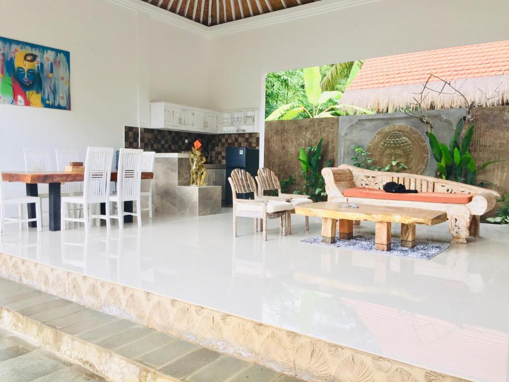sala de estar con suelo blanco, mesa y sillas en Pranajaya loka 2 bed rooms villa, en Tejakula