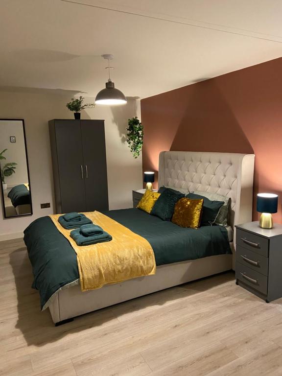 um quarto com uma cama grande com um cobertor amarelo e verde em Home From Home Cosy 2 Bed Apartment em Bradford