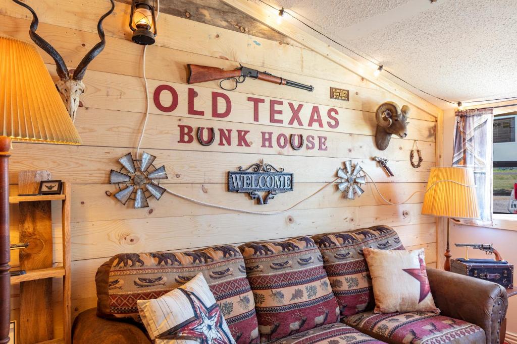 - un salon avec un canapé et un panneau mural dans l'établissement Old Texas Bunkhouse, à Wills Point