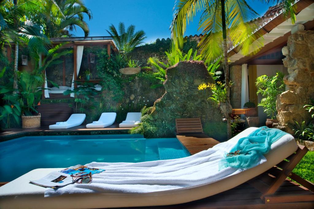 uma cama ao lado de uma piscina em Casa Turquesa - Maison D´Hôtes em Paraty