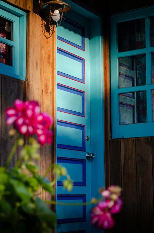 a blue door with pink flowers in front of it at Aquelarre in La Capuera