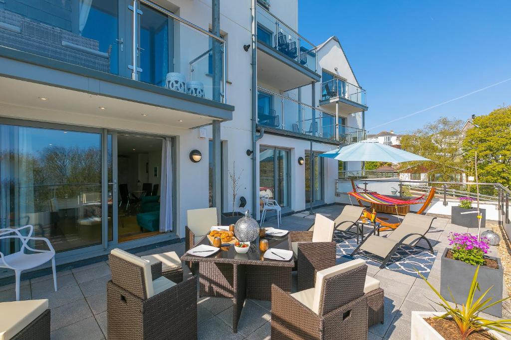 Un patio con una mesa y sillas y una sombrilla. en Sea Glass, en Carbis Bay