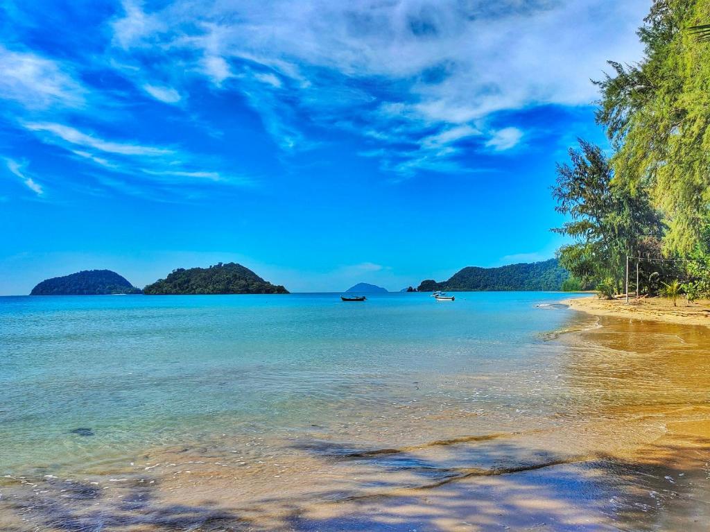 einen Strand mit Inseln im Wasser und blauem Himmel in der Unterkunft Miss You Beach Resort Koh Mak in Ko Mak