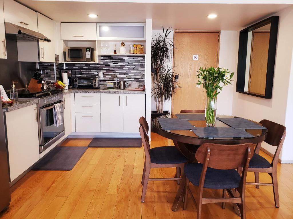 Luxury Apartment in Carso, Polanco في مدينة ميكسيكو: مطبخ وغرفة طعام مع طاولة وكراسي