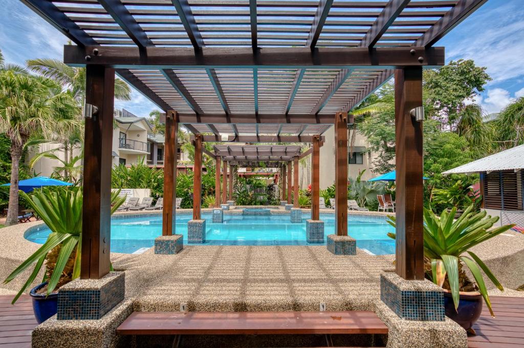 an outdoor pool with a pergola and a swimming pool at Freestyle Resort Port Douglas in Port Douglas