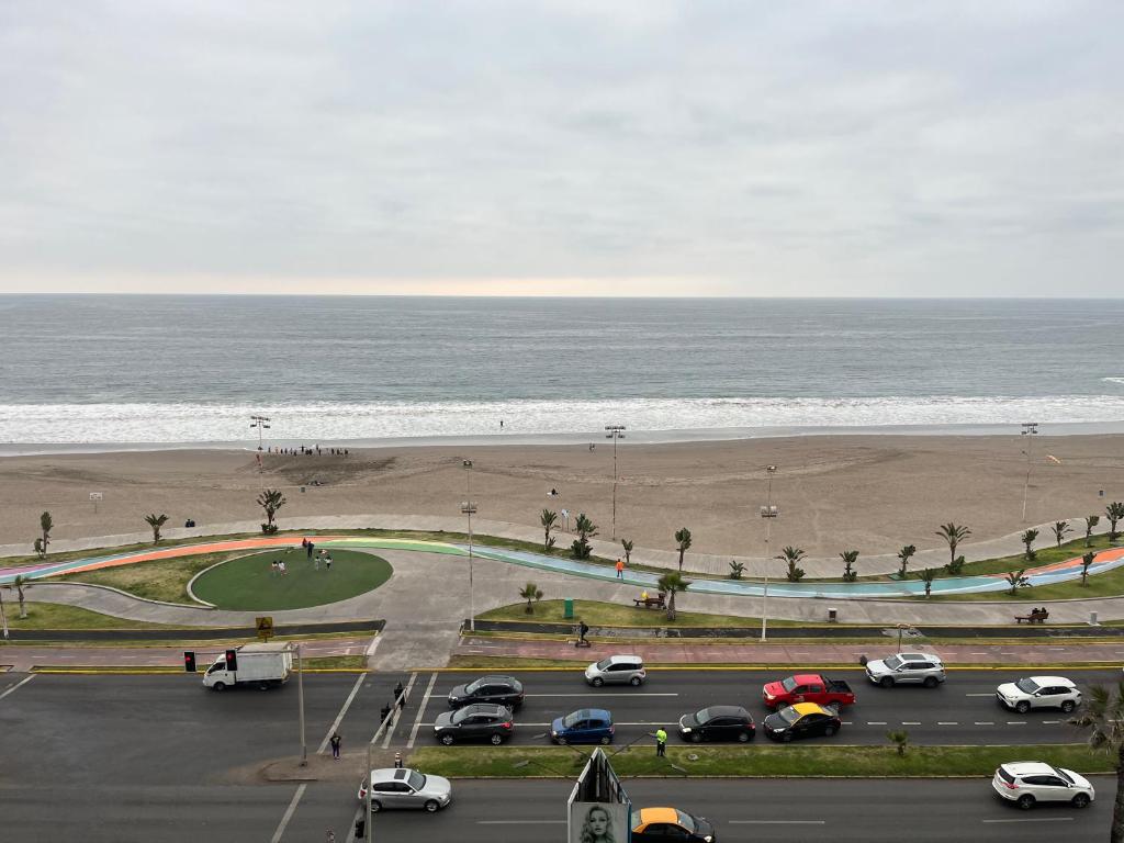 un aparcamiento junto a la playa con coches aparcados en Aguamarina,Apart, en Iquique