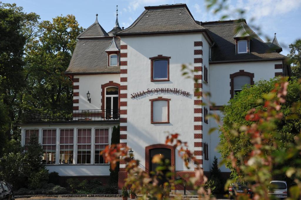 una gran casa blanca con techo negro en Villa Sophienhöhe, en Kerpen