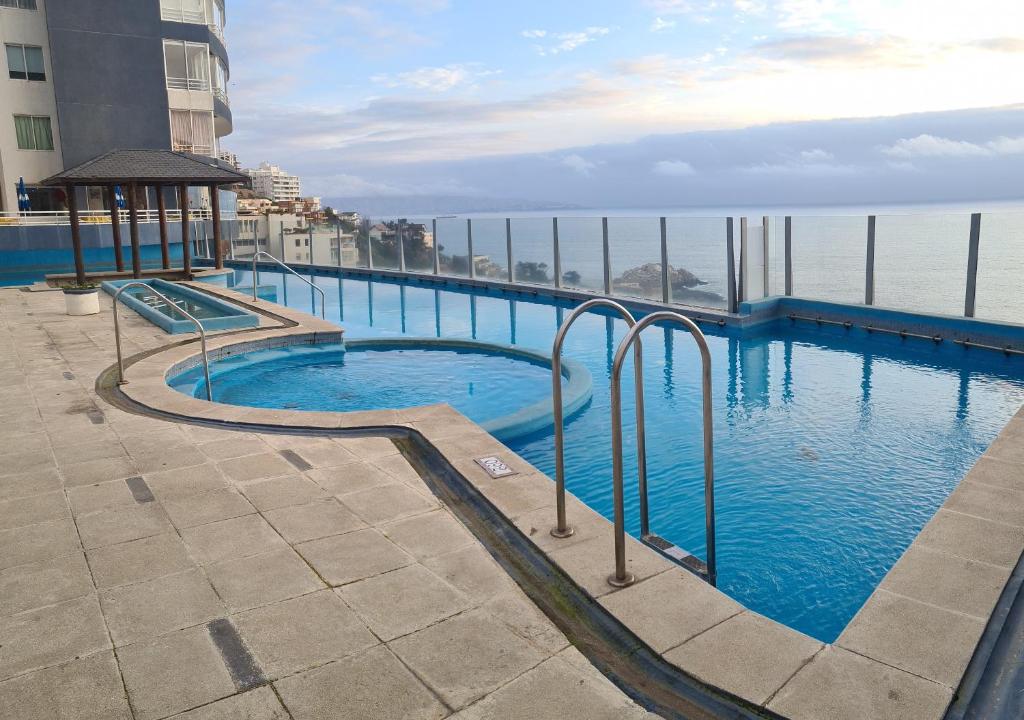 uma piscina no topo de um edifício com a água em Euromarina 2 Reñaca Vista al Mar em Viña del Mar