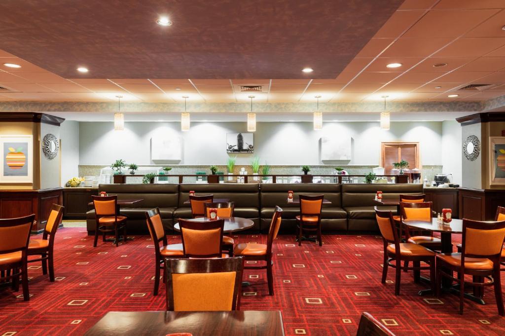a restaurant with tables and chairs and a bar at Crowne Plaza Newark Airport by IHG in Elizabeth