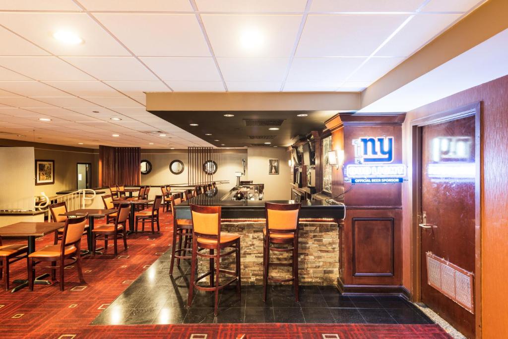 a restaurant with a bar with chairs and tables at Crowne Plaza Newark Airport by IHG in Elizabeth
