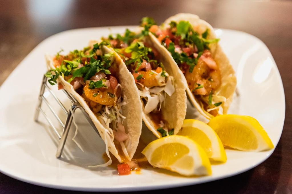 a white plate with three tacos and lemon slices at Crowne Plaza Newark Airport by IHG in Elizabeth