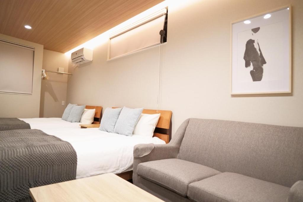 a hotel room with two beds and a couch at Koti Sopo Universal Bay 4 by Liaison in Osaka