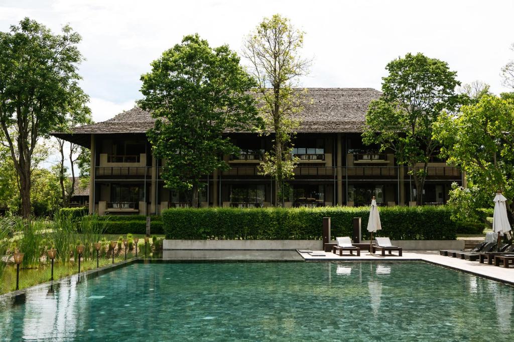 ein Schwimmbad vor einem Gebäude in der Unterkunft Kirimaya Golf Resort Spa - SHA Plus Certified in Mu Si