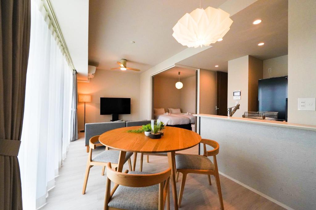 a room with a table and chairs and a bedroom at Branchera Naha 1008 in Naha