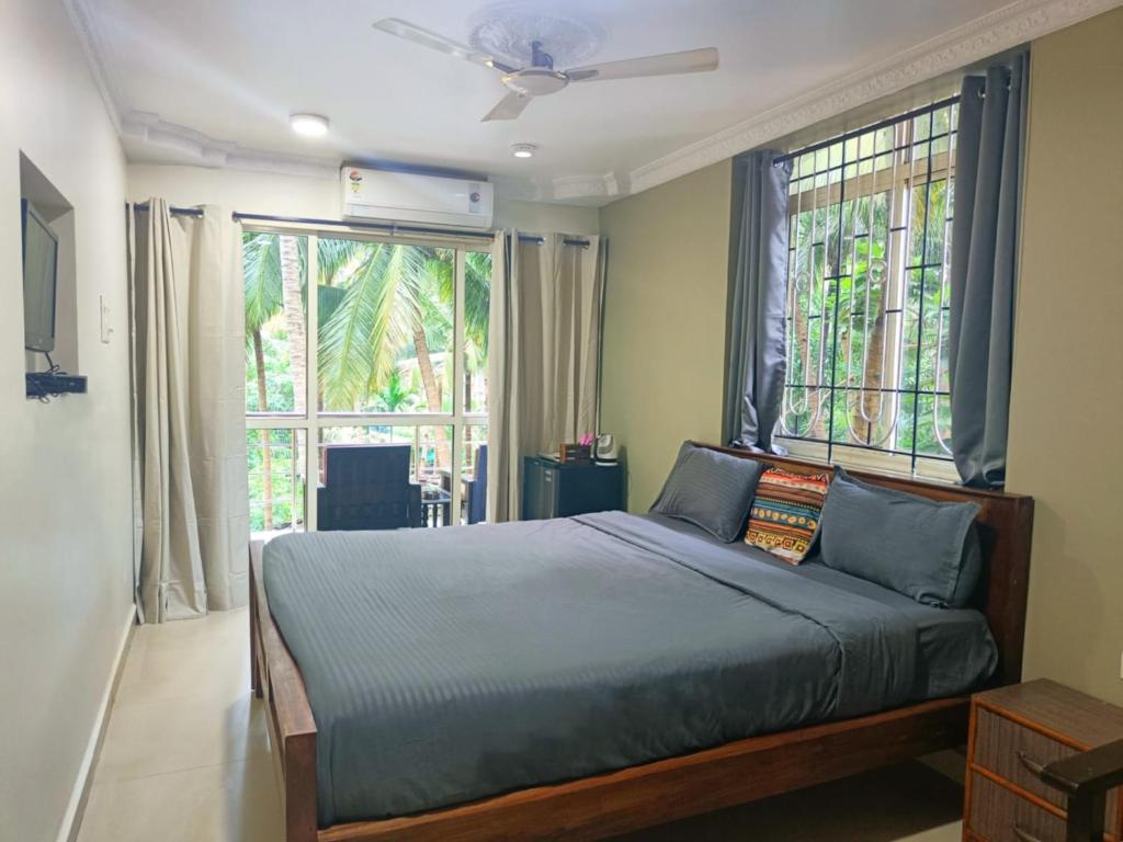 um quarto com uma cama e uma grande janela em Kanvas Suites - Sun N Moon em Palolem