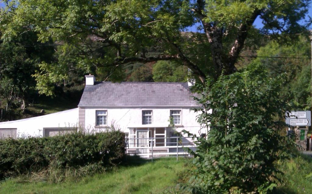una casa blanca en medio de un campo en Bridge House en Glenties
