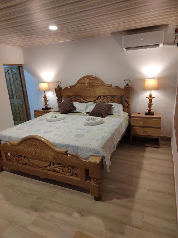 1 dormitorio con 1 cama grande de madera y 2 mesitas de noche en Aparta Suite Villa Roko en San Andrés