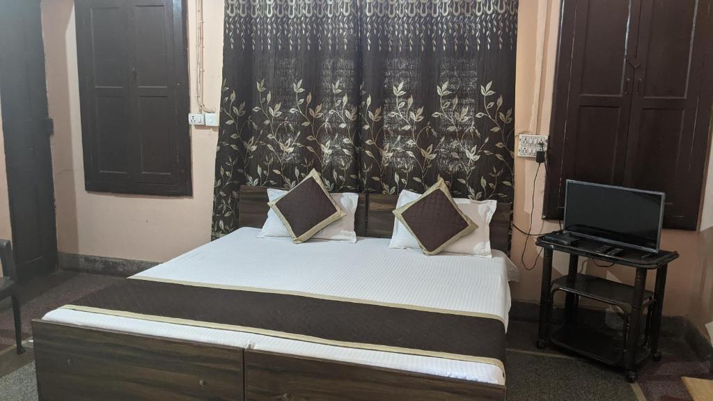 a bedroom with a bed and a television in it at Hotel Kanchan Dehradun in Dehradun