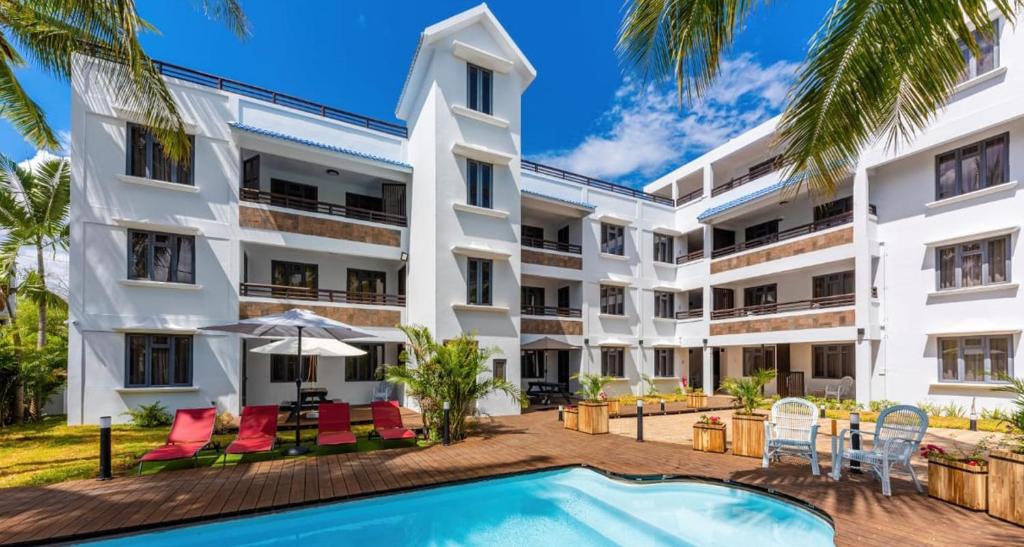 un'immagine dell'esterno di un edificio con piscina di Les Cerisiers - Beach Apartment with Pool, Few Steps to the Beach a Flic-en-Flac