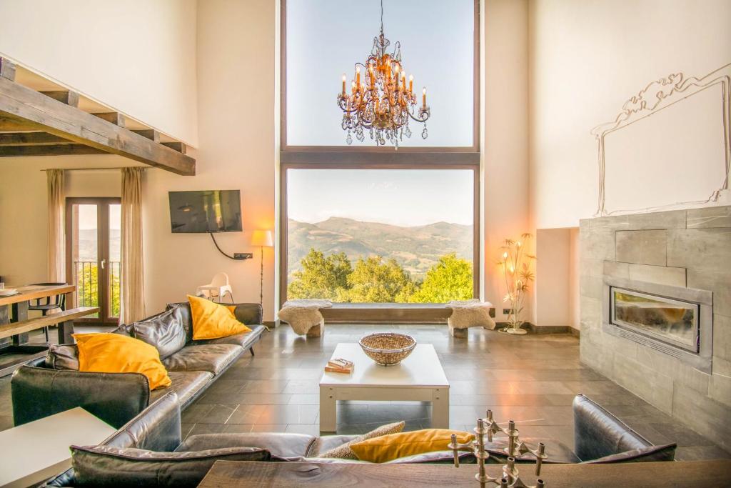 ein Wohnzimmer mit einem Sofa und einem Kamin in der Unterkunft Behin Batean, espectacular casa rural en pleno corazón del valle Baztán in Ziga