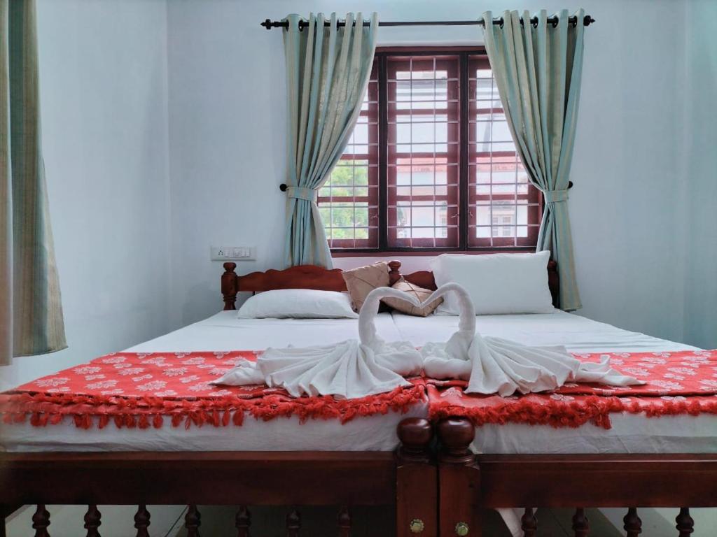 dos cisnes blancos están sentados en una cama en joseys homestay, en Kochi