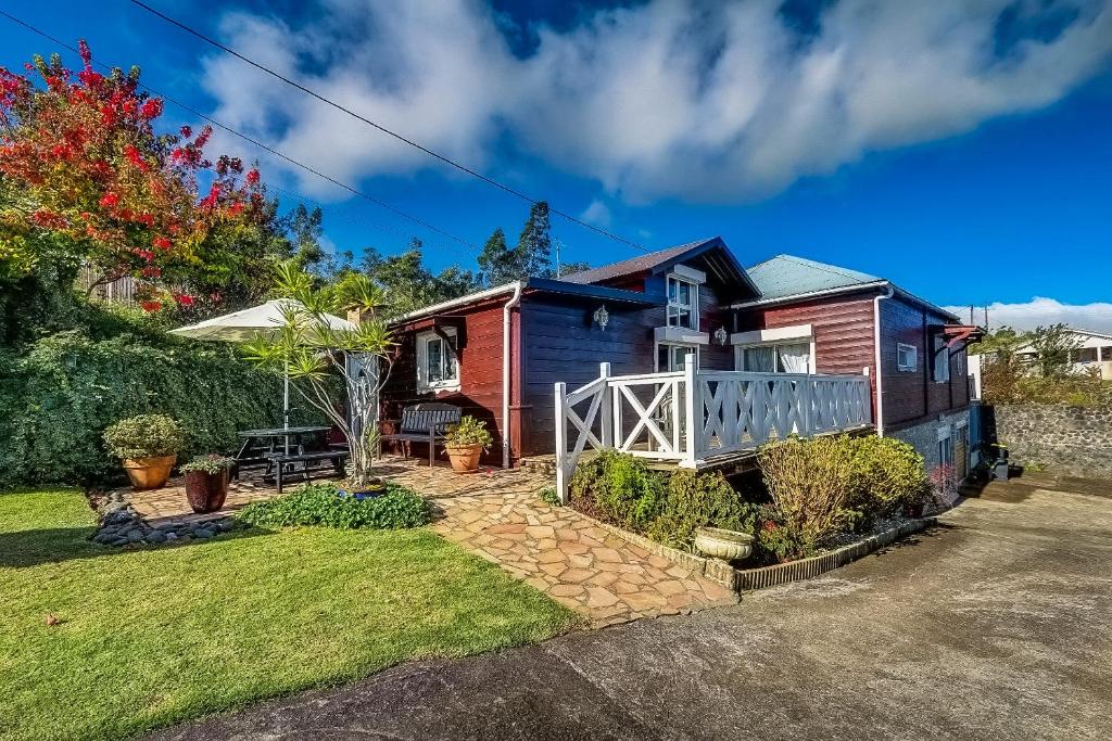 a house with a porch and a yard at Les Terrasses du Volcan in Le Tampon