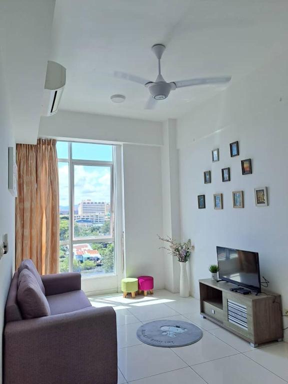 a living room with a couch and a television at Chill Stay @Sutera Avenue in Kota Kinabalu