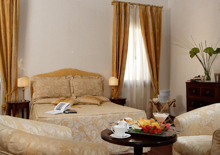 a bedroom with a bed and a table with a tray of fruit at La Rosa dei Venti in Venice