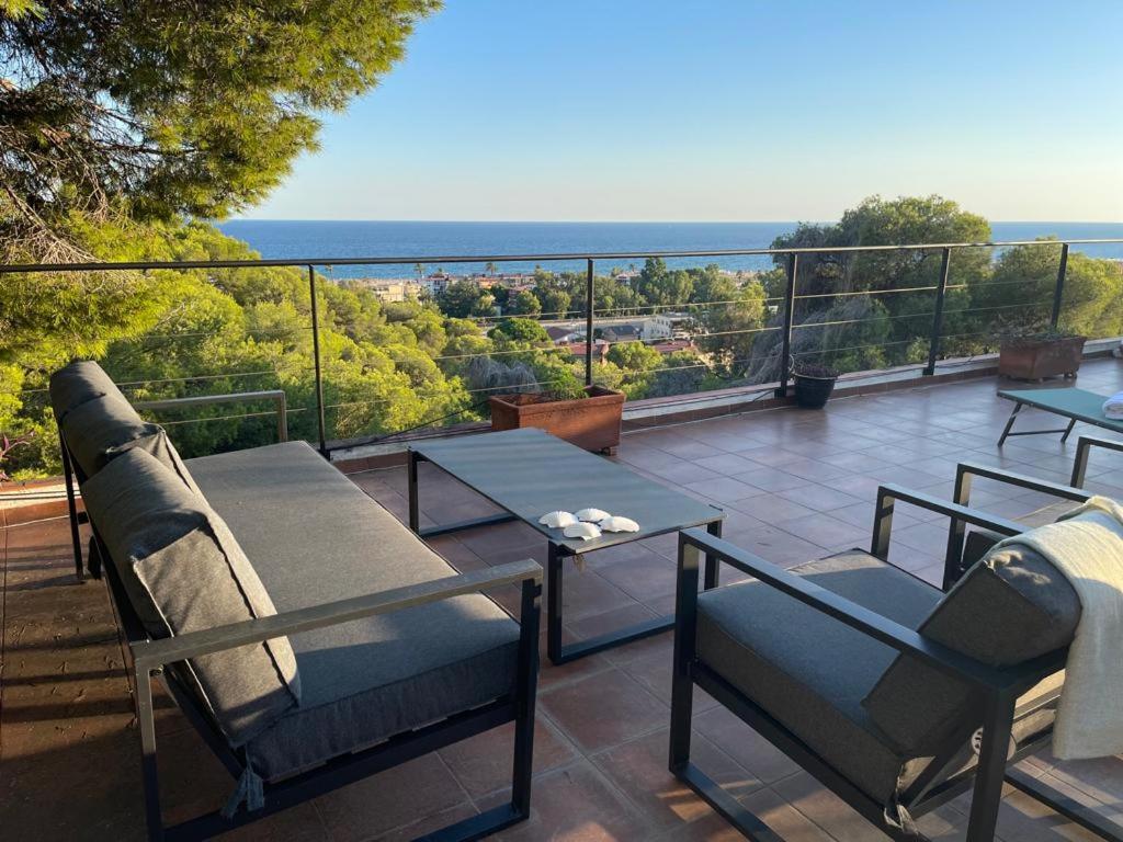 een balkon met een tafel en stoelen en de oceaan bij Villa Bella in Castelldefels