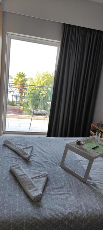 um quarto com uma cama com uma mesa e uma grande janela em Ilianna's Home Β3 - Marina,Kalamata em Kalamata