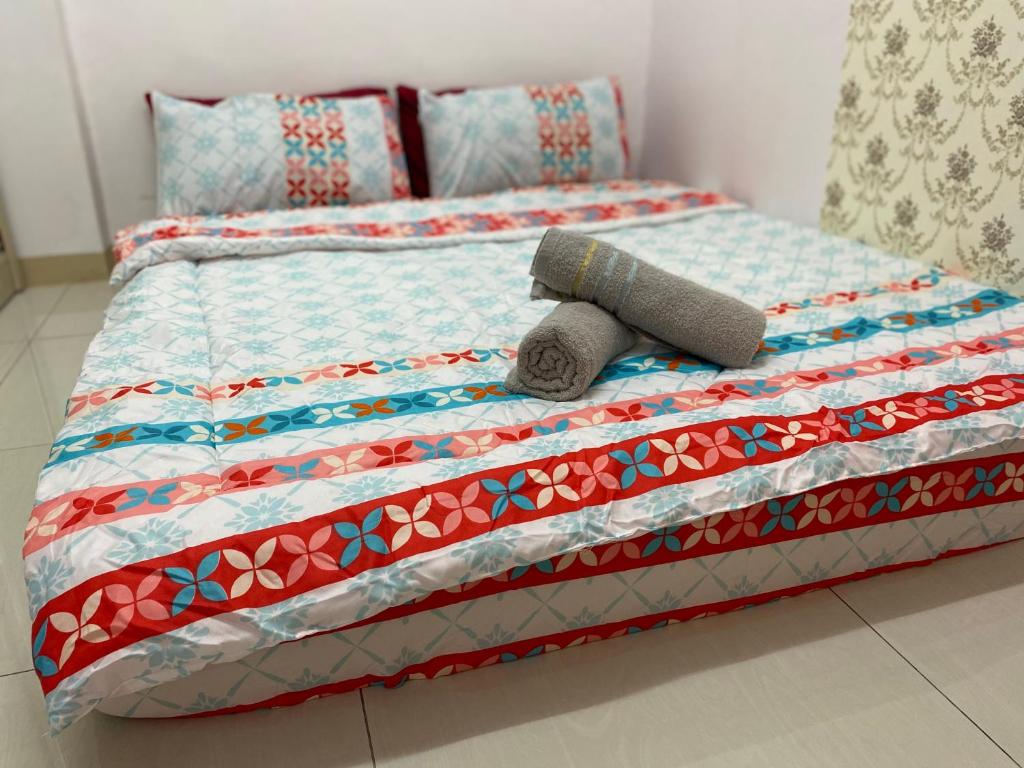 a bed with a quilt and a roll on it at 9293 Taman Sri idaman in Ayer Itam